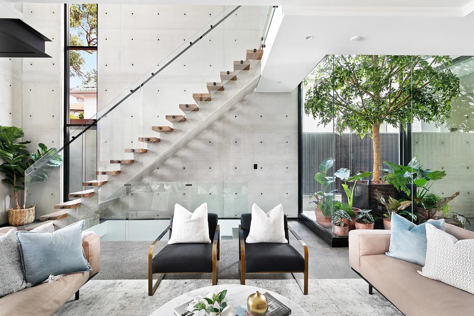 Concrete stair at The Arc beside full-height glazing and the internal garden