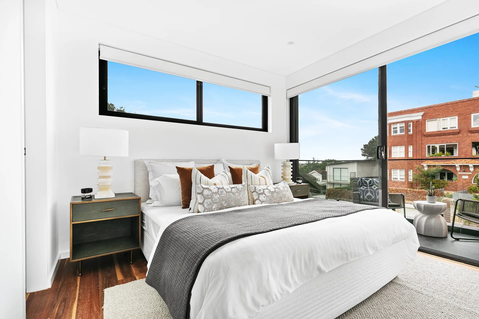 Upper-level bedroom at The Arc in Bondi Beach with corner glazing and district views