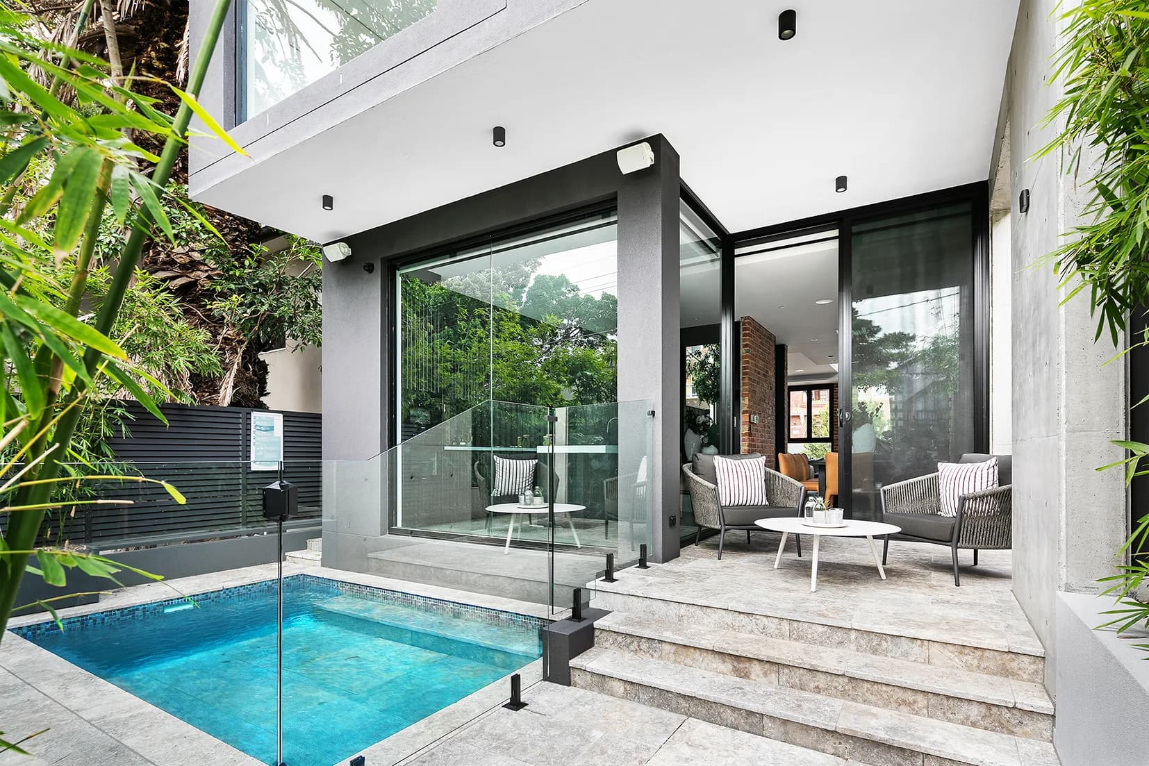 Travertine terrace and plunge pool at The Arc finished in Black Russian mosaic tiles