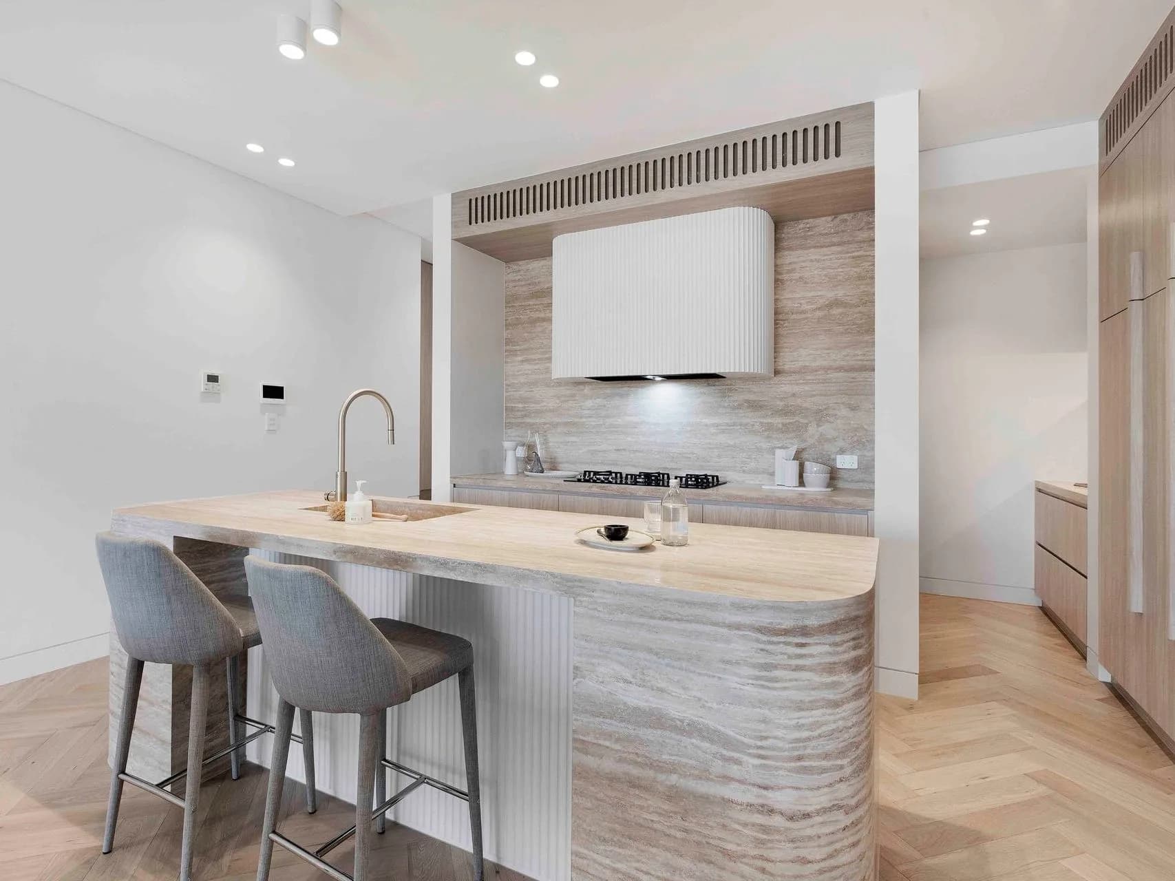 Kitchen at Hillary with a travertine island bench, Polytech joinery and Smeg Dolce Stil Novo appliances