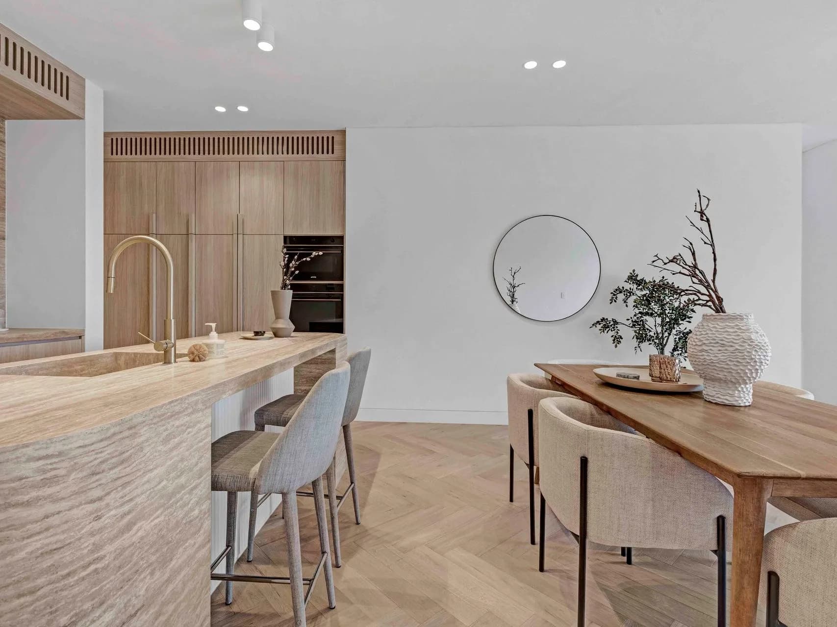 Kitchen and dining at Hillary in Matraville with travertine benchtops, timber stools and herringbone oak floors