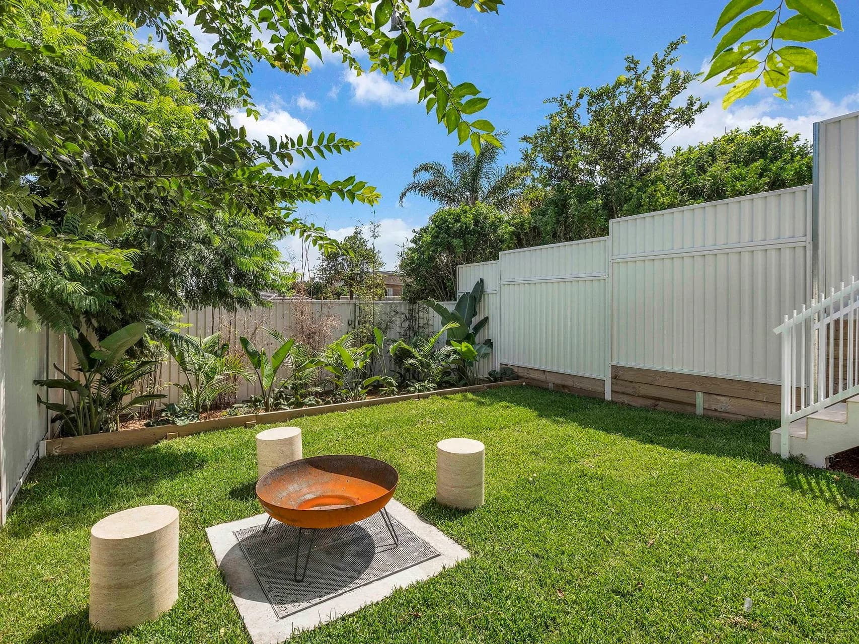 Landscaped rear garden at Hillary in Matraville with a sculpted steel fire pit and lawn
